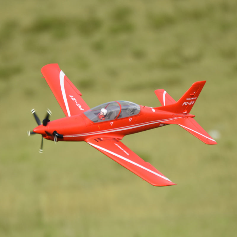 FMS PC-21 Pilatus red RC aircraft in flight with detailed features.