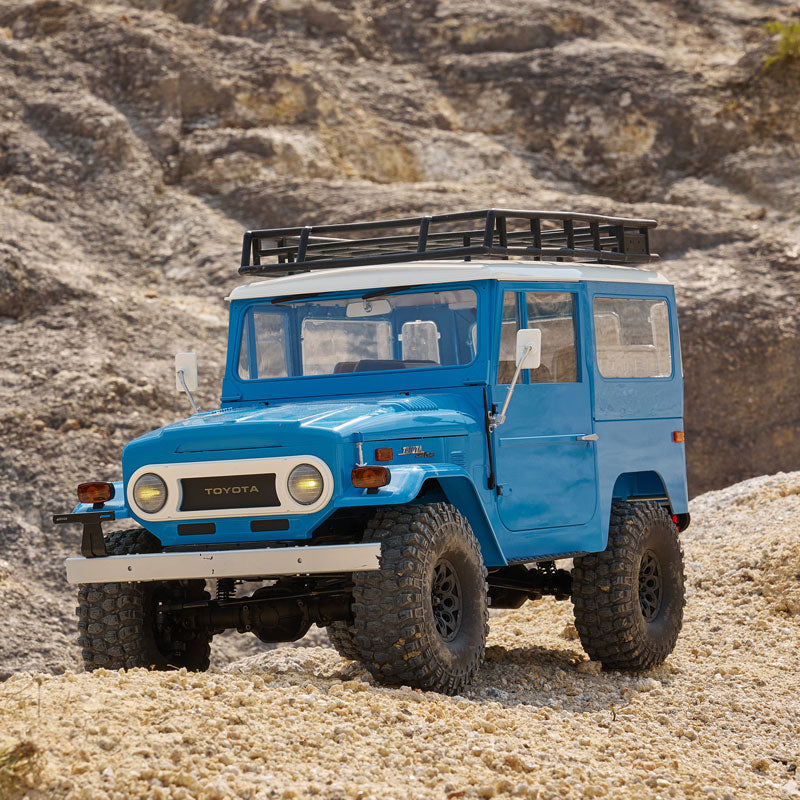 FMS 1:10 Toyota Land Cruiser FJ40 RS in blue on rocky terrain